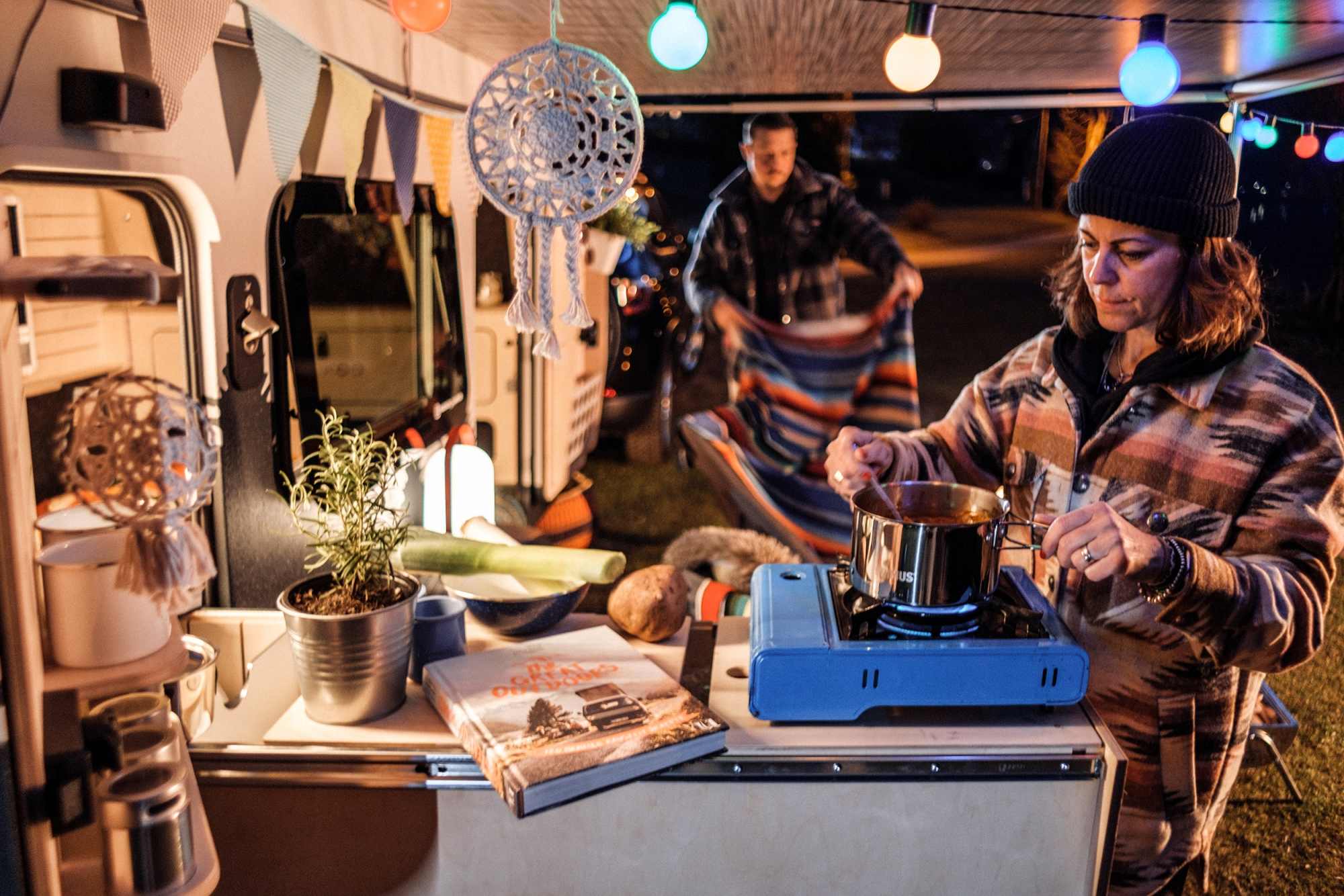 Bruno - Miniwohnwagen aussen beim Kochen mit Lichtern und Markise